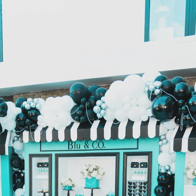 the entrance to bu & co is decorated with black and white balloons