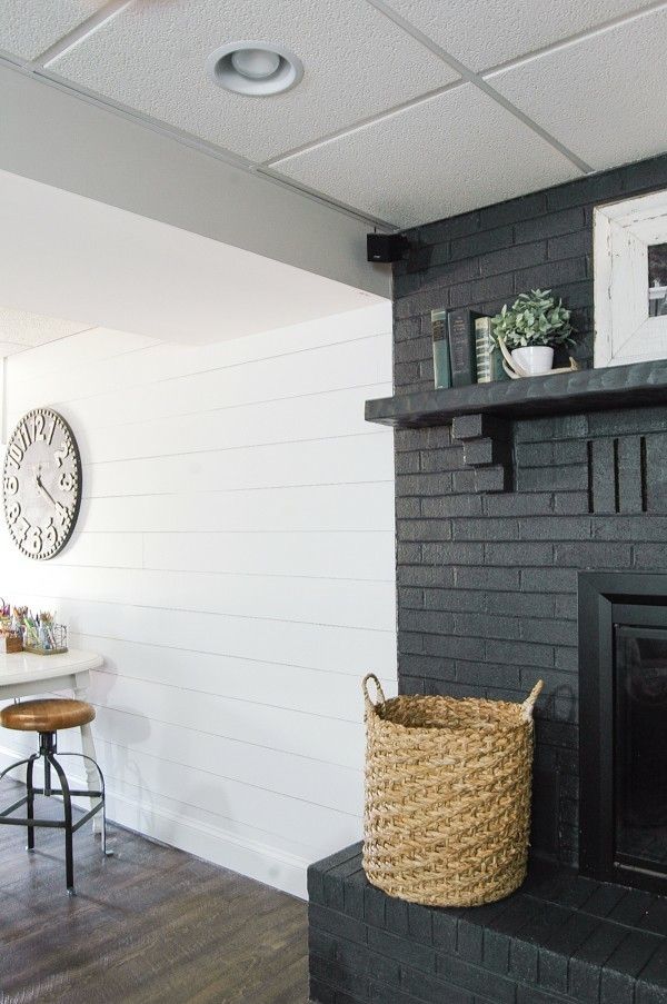 a living room with a fire place and a clock on the wall next to it