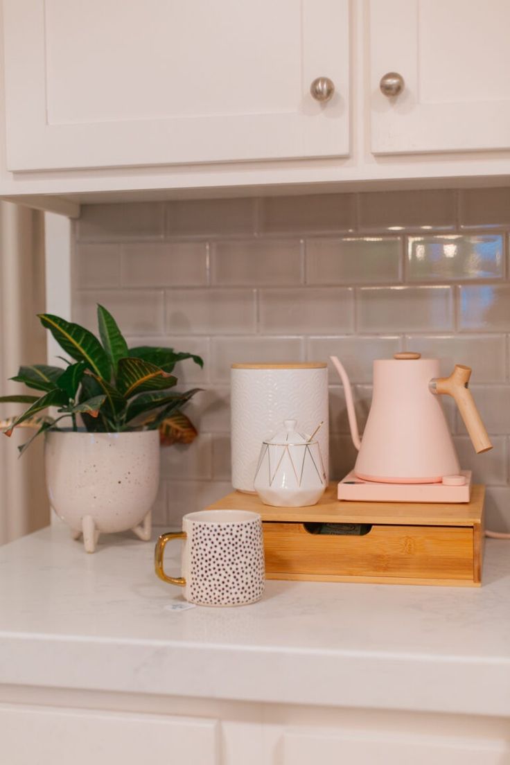 the kitchen counter is clean and ready to be used as a coffee pot, tea kettle, and cup holder