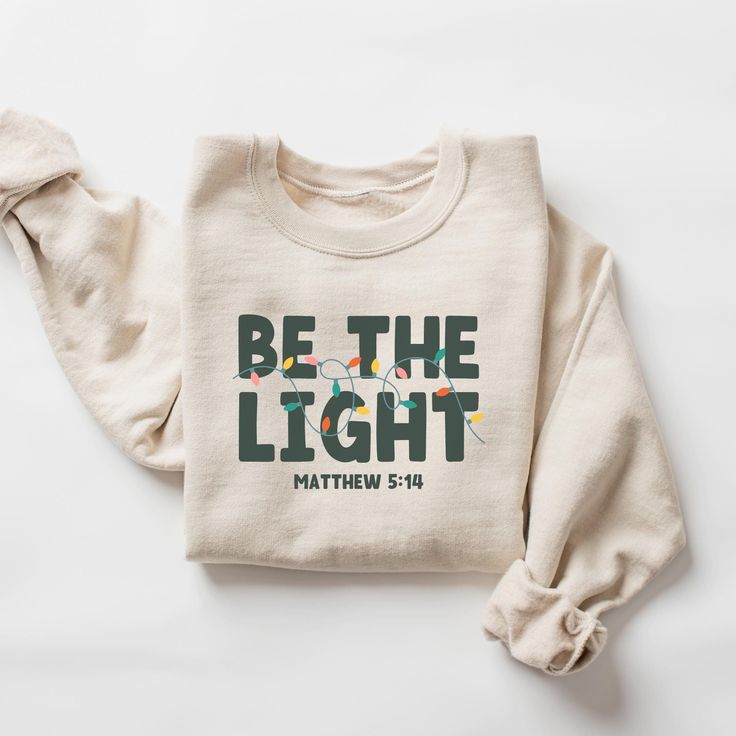 Shine Bright this Christmas with our "Be The Light" Sweatshirt! Inspired by Matthew 5:14, this cozy and inspirational sweatshirt is a beautiful reminder to let your faith shine and be a light in the world. It's perfect for spreading Christmas cheer, attending church services, or simply expressing your devotion in everyday life. Crafted from soft, comfortable materials, this unisex sweatshirt is ideal for cozy days and festive nights. It also makes a thoughtful and meaningful gift for loved ones Faith Based Gifts, Inspirational Shirts, Be The Light, Religious Christmas, Xmas Shirts, Holiday Sweatshirt, Christian Christmas, Family Christmas Shirts, Inspirational Shirt