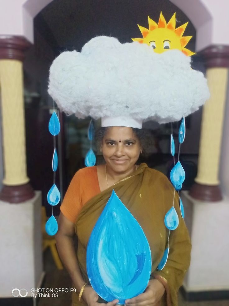 a woman wearing a cloud hat and holding a blue water droplet