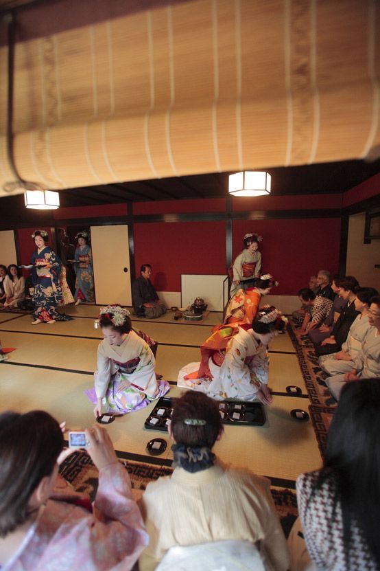 a group of people sitting on top of a wooden floor