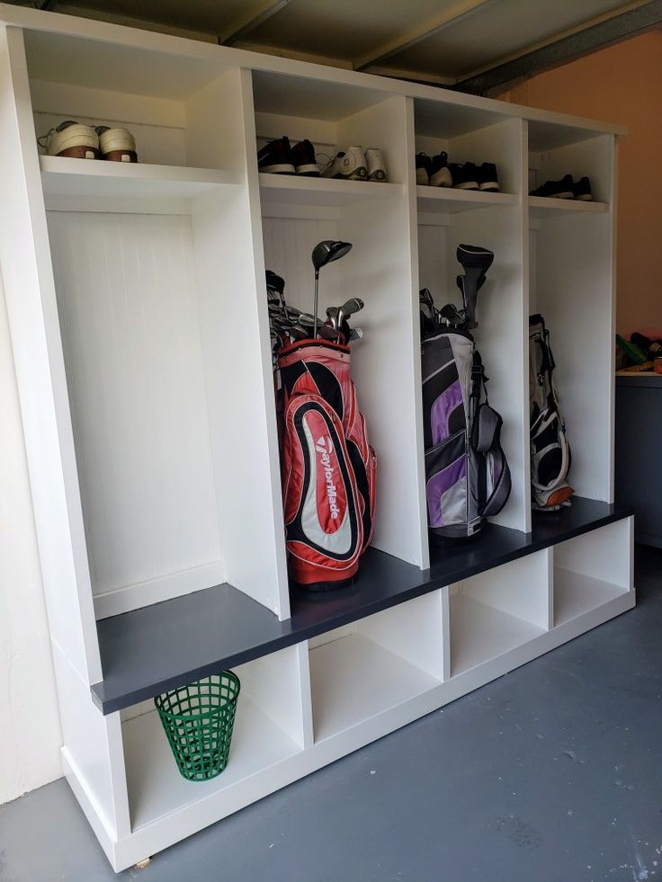 the golf bags are lined up on the shelves in the locker room, and ready to be used