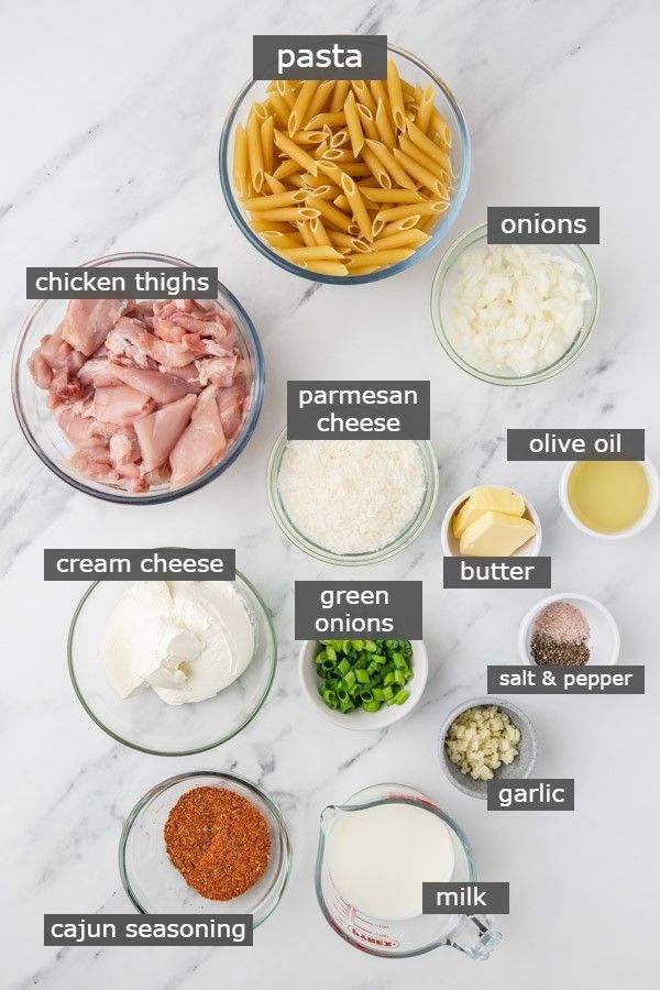 the ingredients to make pasta in bowls on a white marble counter top, including chicken, cheese, parmesan and other ingredients