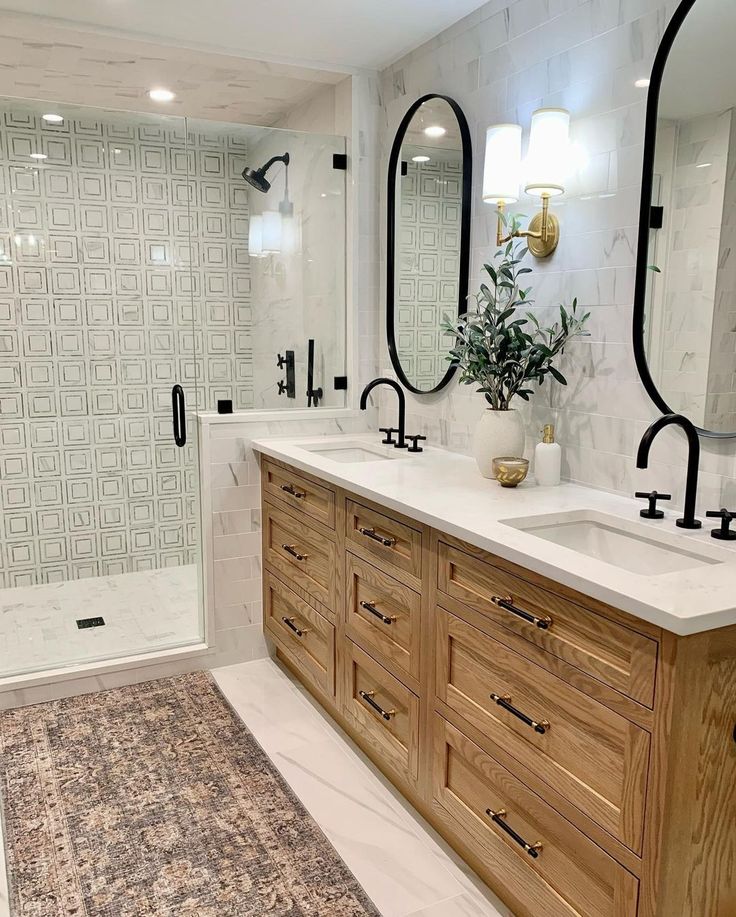 a bathroom with two sinks, mirrors and a rug on the floor in front of it