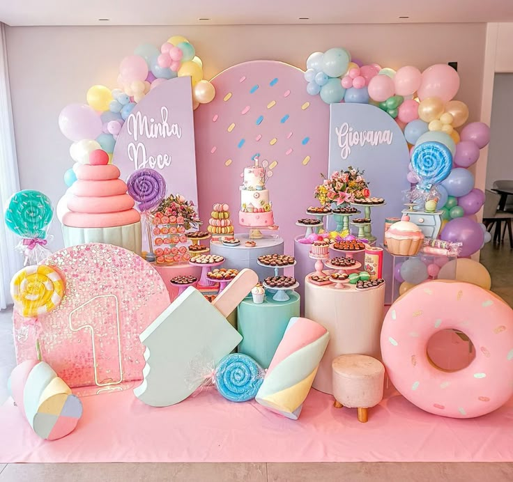 a table topped with lots of desserts and balloons