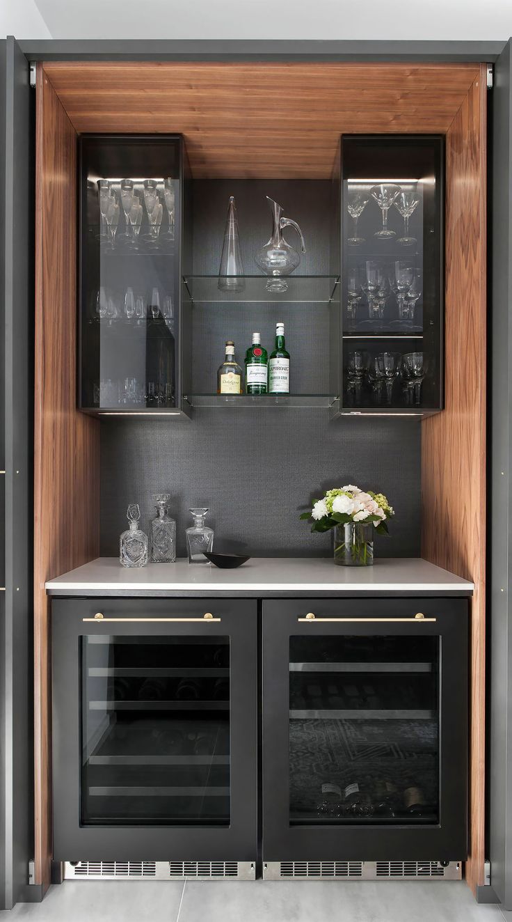 an open cabinet with wine glasses and bottles in it