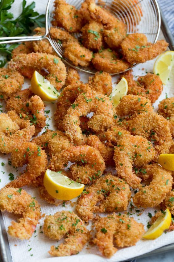 fried shrimp with lemon wedges and parsley on a serving platter, ready to be served