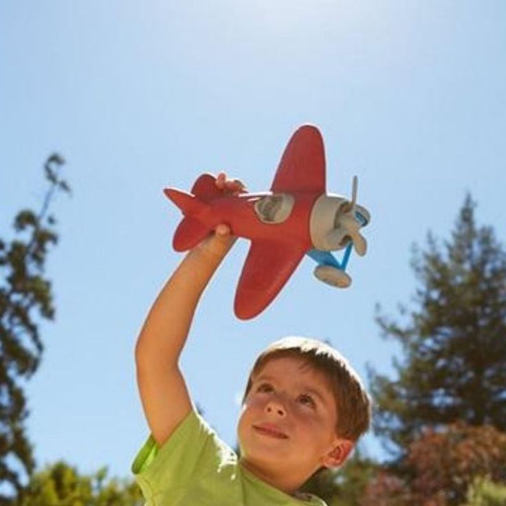 a young boy holding up a toy airplane