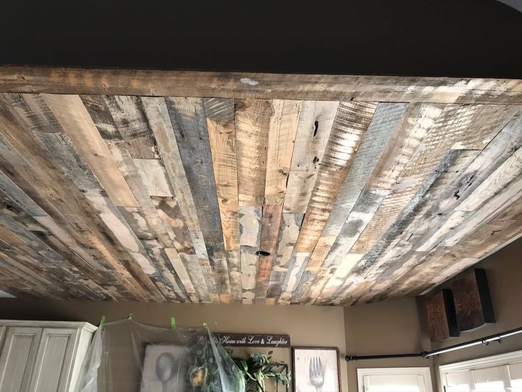 a wooden ceiling in a kitchen with white cabinets