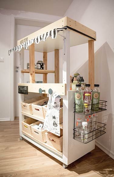 a small kitchen with an island made out of wooden pallets and storage bins