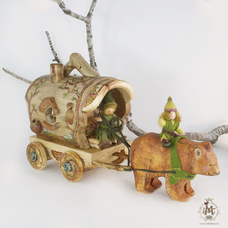 a figurine of an animal pulling a carriage with two people riding on it