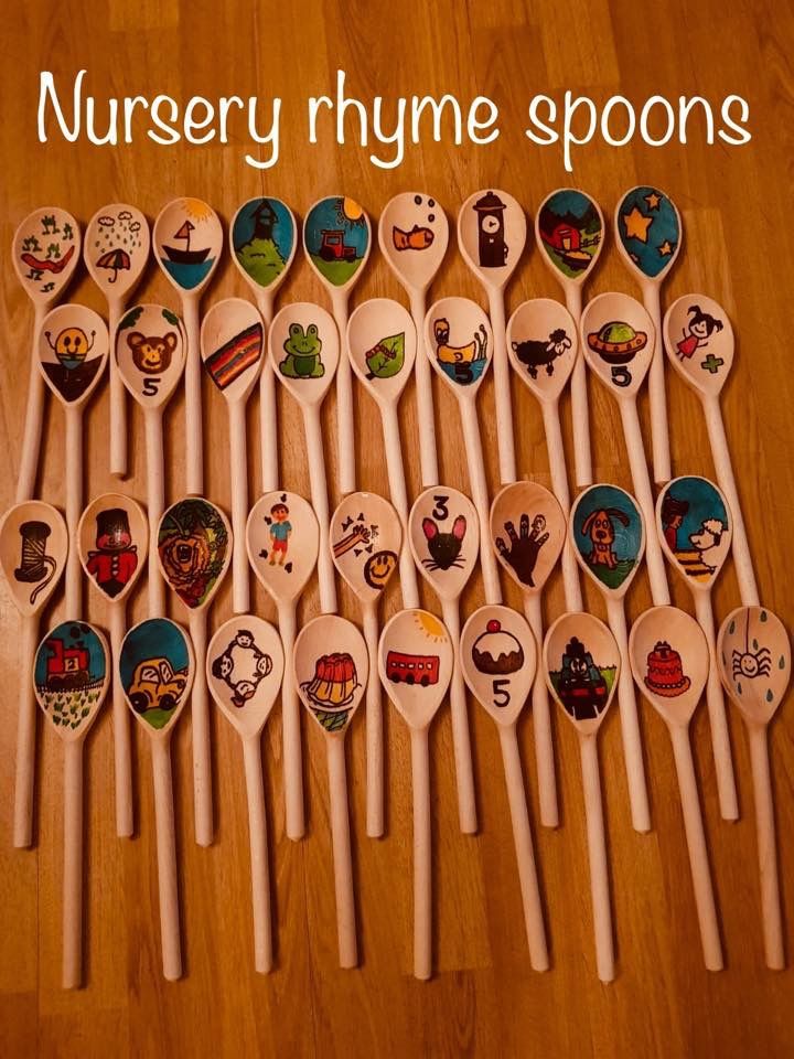 many wooden spoons with cartoon images on them are lined up in a row against a wood floor