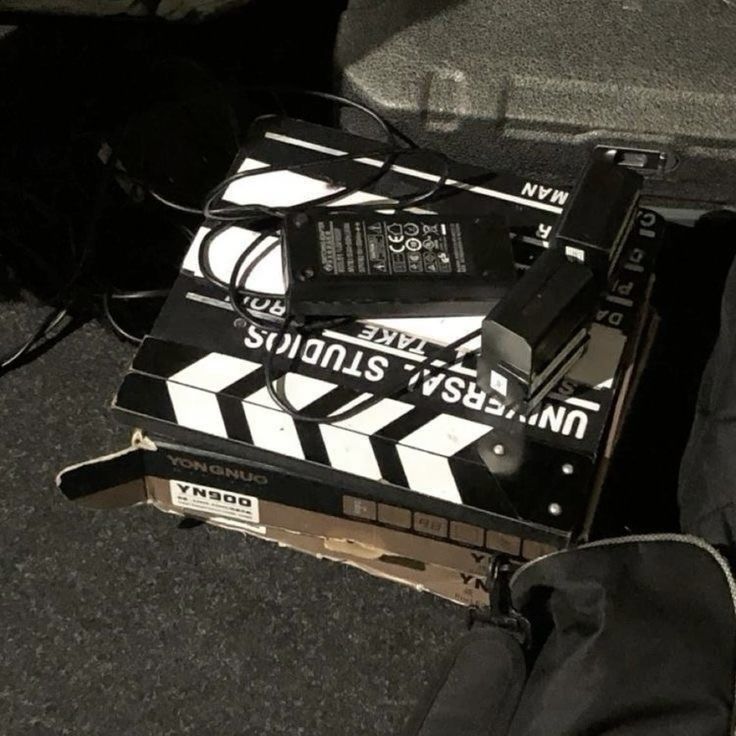 a black and white movie clapper sitting on top of a piece of luggage next to a bag