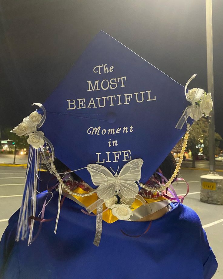 a blue graduation cap that says the most beautiful moment in life with butterflies on it