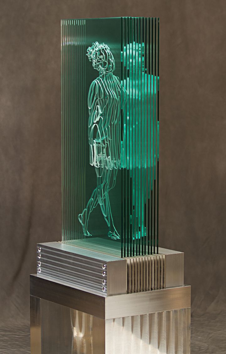 a glass sculpture with a person walking on it