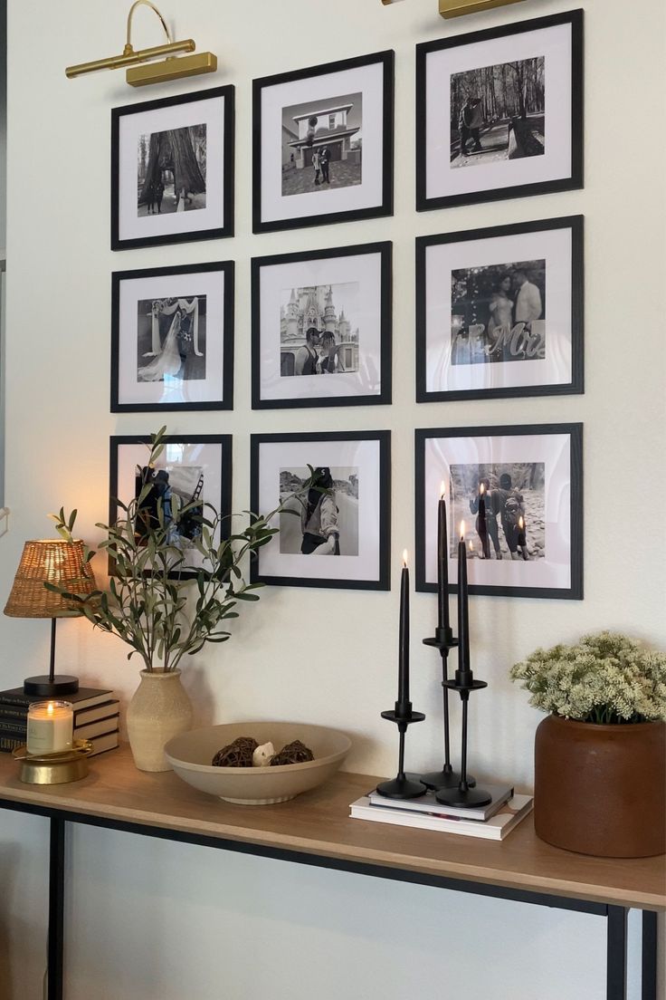 there are many pictures on the wall with candles and plants in front of each one