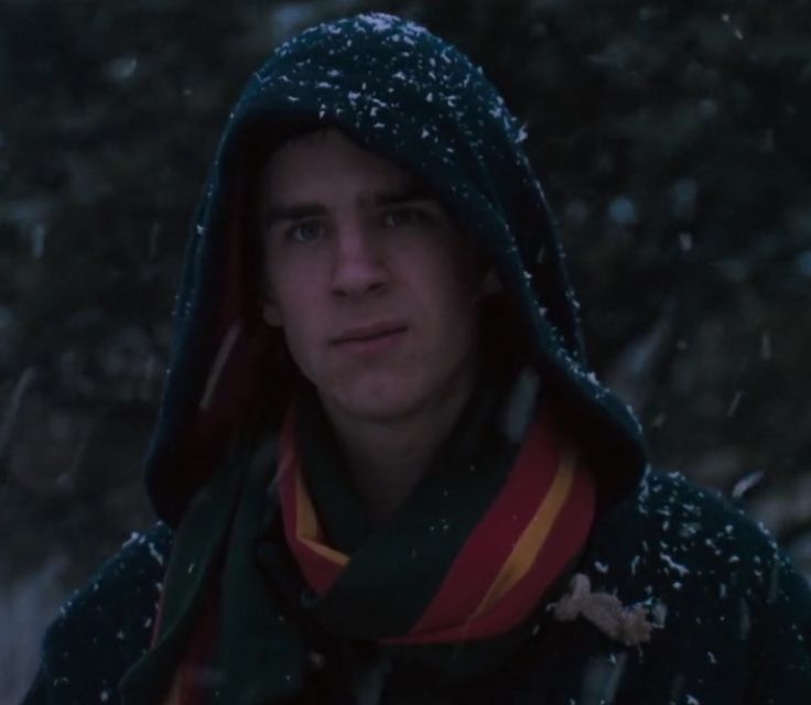 a young man wearing a scarf and hoodie in the snow