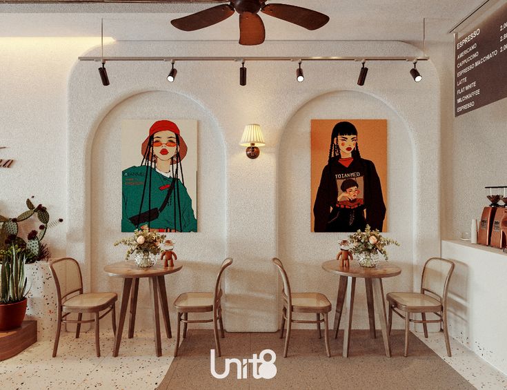 the interior of a restaurant with art on the walls