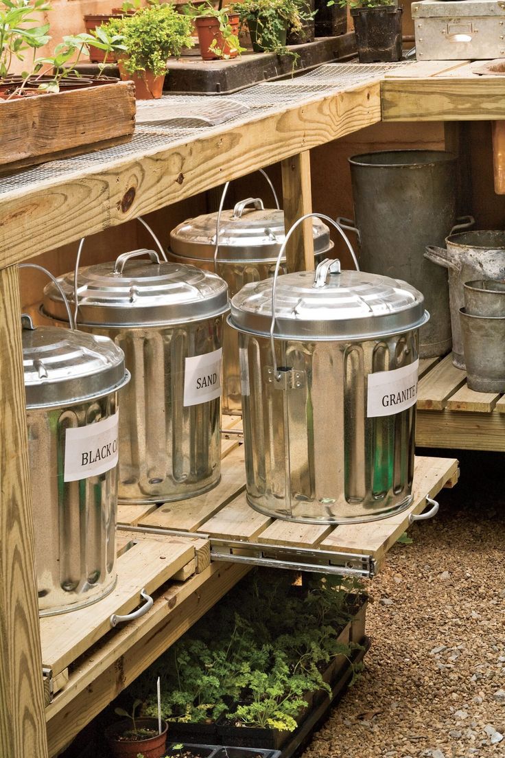 pots and pans are sitting on the shelves in an outdoor garden area that is filled with plants