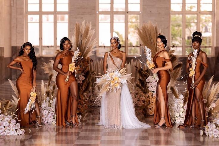 a group of women standing next to each other in front of flowers and feathers on display