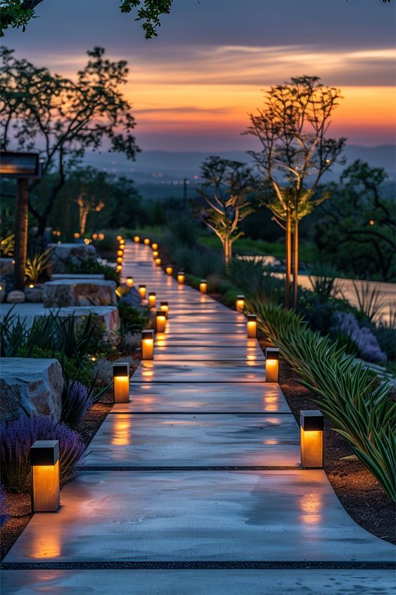 a walkway lined with lit candles next to trees