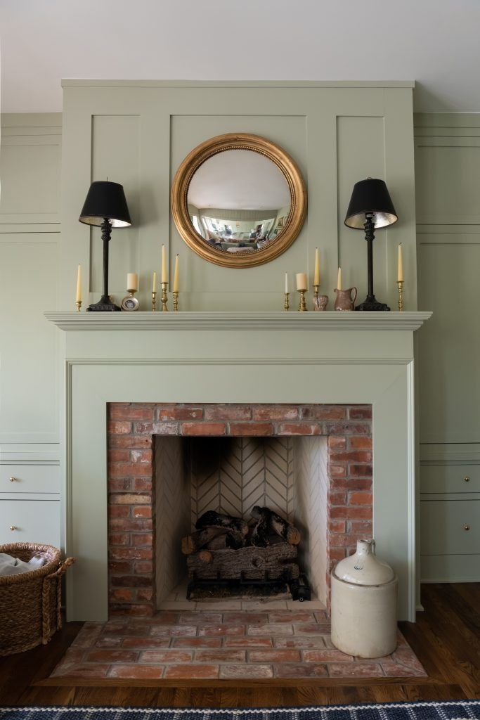 a fireplace with a mirror above it and two lamps on either side of the fire place