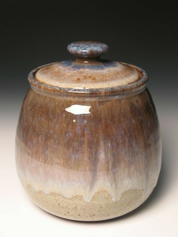 a brown and white ceramic jar with a lid