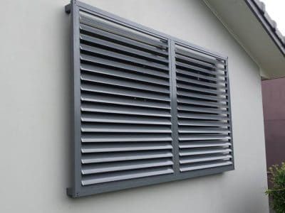 a close up of a window on the side of a building with shutters open