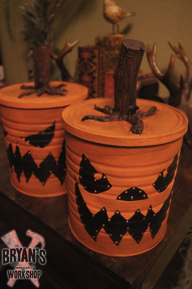 three clay pots with designs on them sitting on a wooden table next to a tree