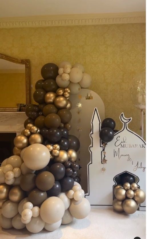 balloons are stacked on top of each other in the shape of a tower with a clock