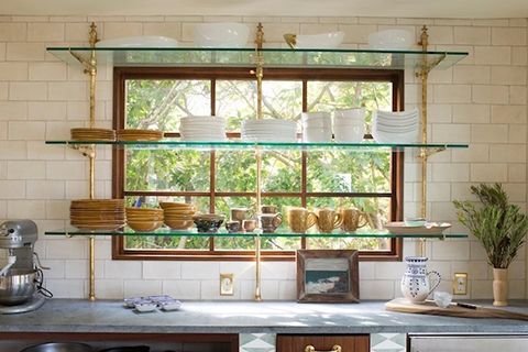 the kitchen is clean and ready to be used for cooking or baking, with dishes on glass shelves