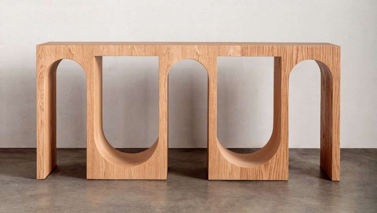 three wooden objects sitting next to each other on the floor in front of a white wall