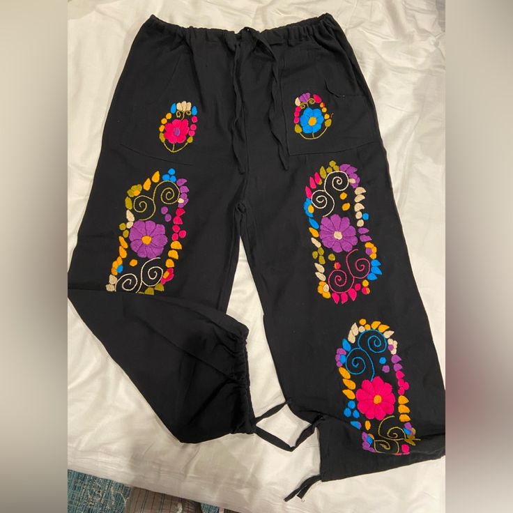 Mexican Embroidered Pants. Black, Cotton/Linen Like Fabric, Drawstring Around Waist & Ankles To Adjust To Your Liking. Pockets In Front. Size Large. Bought On Etsy But Too Big For Me. Brand New, Never Worn. Very Cute! Casual Vacation Bottoms With Floral Embroidery, Casual Floral Embroidery Bottoms For Vacation, Casual Floral Embroidered Bottoms For Vacation, Casual Black Embroidered Bottoms, Black Embroidered Cotton Bottoms, Casual Embroidered Cotton Pants, Casual Black Embroidered Pants, Casual Floral Embroidered Loungewear Bottoms, Casual Floral Embroidery Loungewear Bottoms