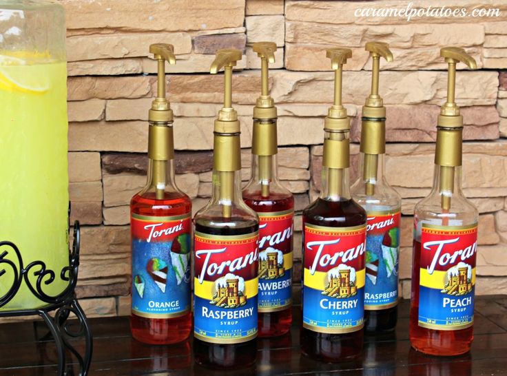 four bottles of torquita on a table next to a glass with lemonade in it