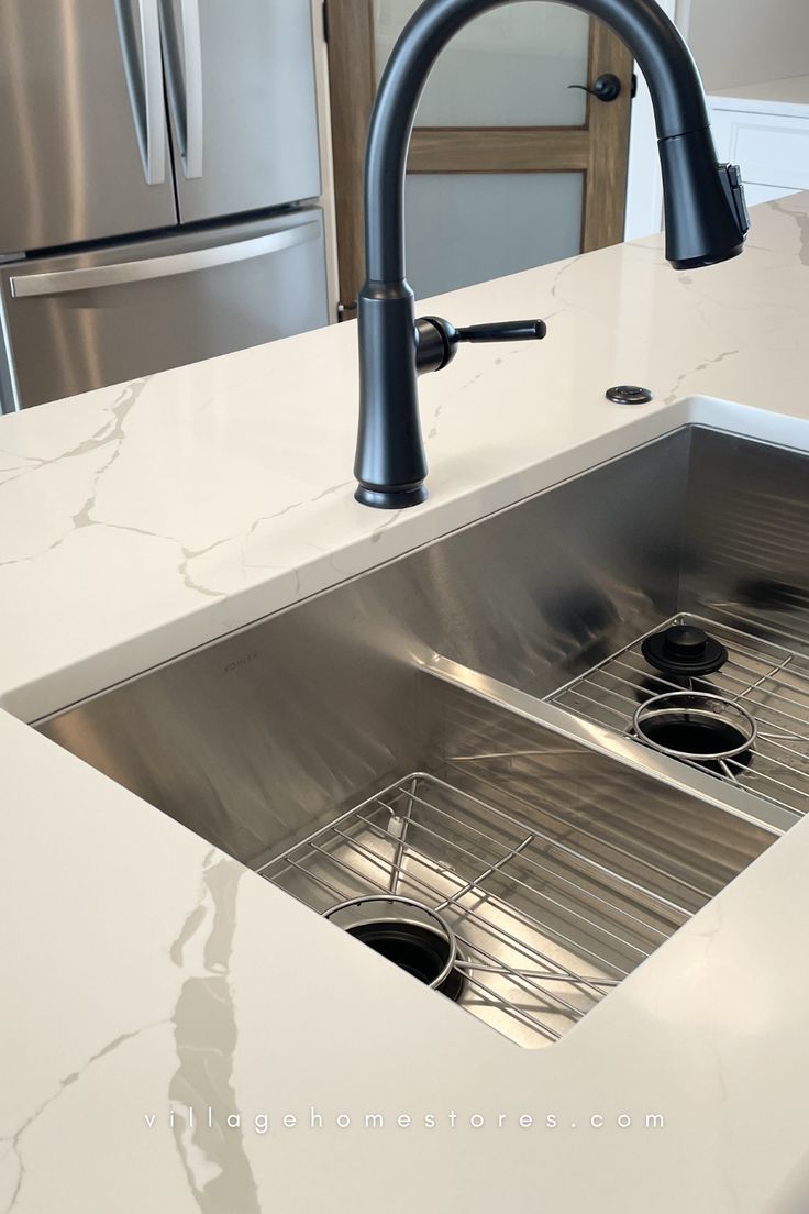 white quartz countertops with stainless steel undermount sink installed with matte black faucet and garbage disposal button Garbage Disposal Button, Kitchen Sink Install, Home Stores, Village Home, Engineered Quartz, Countertop Surfaces, Steel Kitchen Sink, Quartz Counter, Marble Vanity Tops