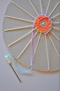 the yarn is being used to make an origami fan with needles and yarn