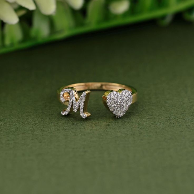 This 14K yellow gold heart ring, adorned with 0.17 carats of round diamonds, is personalized with the letter "M" and available in A-Z initials. A thoughtful anniversary gift or special present for her, this initial letter ring combines elegance and sparkle with a meaningful touch, making it a cherished addition to any jewelry collection. - Diamond Detail:- ↦ Diamond Shape: Round ↦ Diamond Weight: 0.17 CTW (approx) ↦ Diamond Clarity: VS ↦ Diamond Color: GH ↦ Diamond Cut: Excellent - Metal Detail: Anniversary Heart-shaped Yellow Gold Initial Ring, Yellow Gold Heart-shaped Initial Ring For Weddings, M Inital Ring, Heart-shaped Initial Ring Gift, Yellow Gold Heart-shaped Initial Ring For Valentine's Day, Gold Heart Ring, Letter Ring, Diamond Heart Ring, Presents For Her