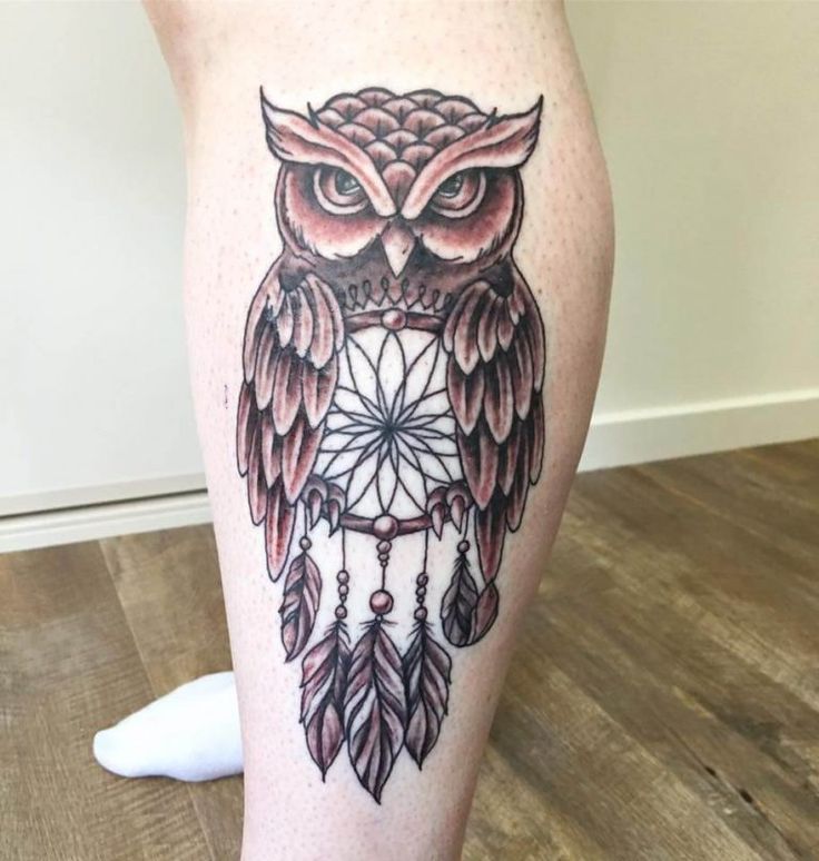 an owl with feathers and dream catcher tattoo on the leg