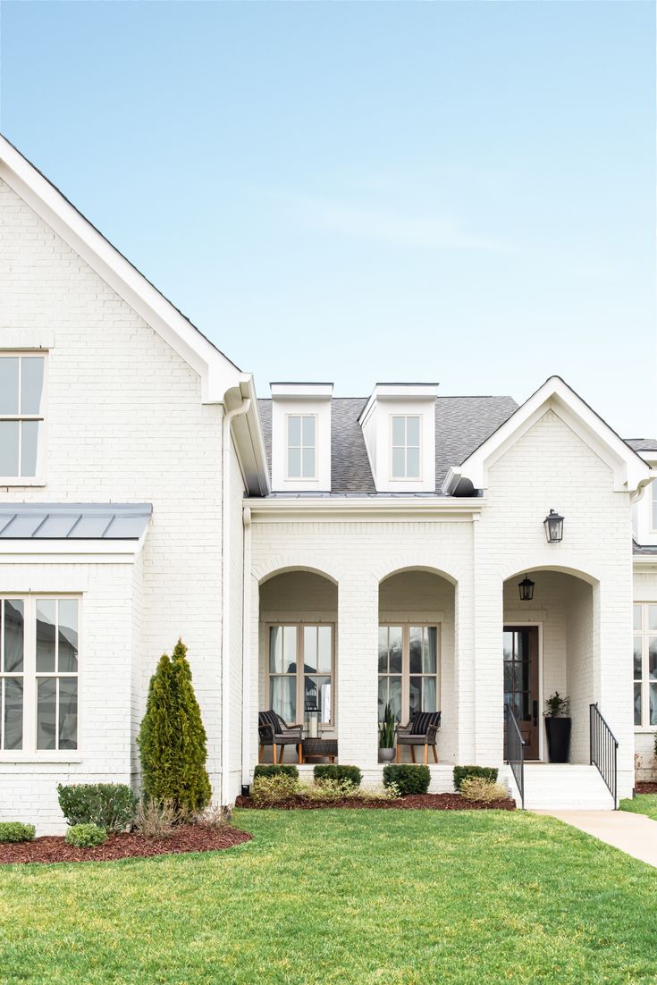 a large white house with lots of windows and grass in front of the door area