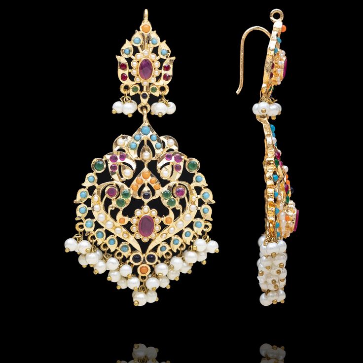 A dazzling fusion of tradition and modern allure - perfect for this festive season to pop some color in your radiant celebrations! Elevate your style with this enchanting ensemble that seamlessly blends the richness of nauratan stones with the classic charm of faux pearls. The set includes a necklace, a maang teekah and a pair of matching earrings. Approximate earrings length is 3.2". Gold-plated on high-quality brass as the base metal. Made by order. Kindly allow 5-7 weeks for the delivery of t Festive Fusion Style Meenakari Bridal Necklace, Festive Fusion Style Jeweled Jhumkas, Fusion Style Chandbali Bridal Necklace For Festivals, Fusion Style Bridal Earrings For Diwali Celebration, Fusion Bridal Earrings For Diwali Celebration, Festive Chandbalis With Cutdana For Celebrations, Fusion Style Jeweled Kundan Jhumkas, Festive Multicolor Kundan Necklace With Intricate Design, Temple Jewelry Style Multi-stone Kundan Necklace For Festive Occasions