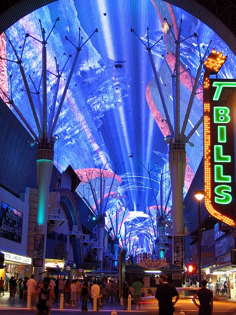 people are walking around in front of an illuminated building