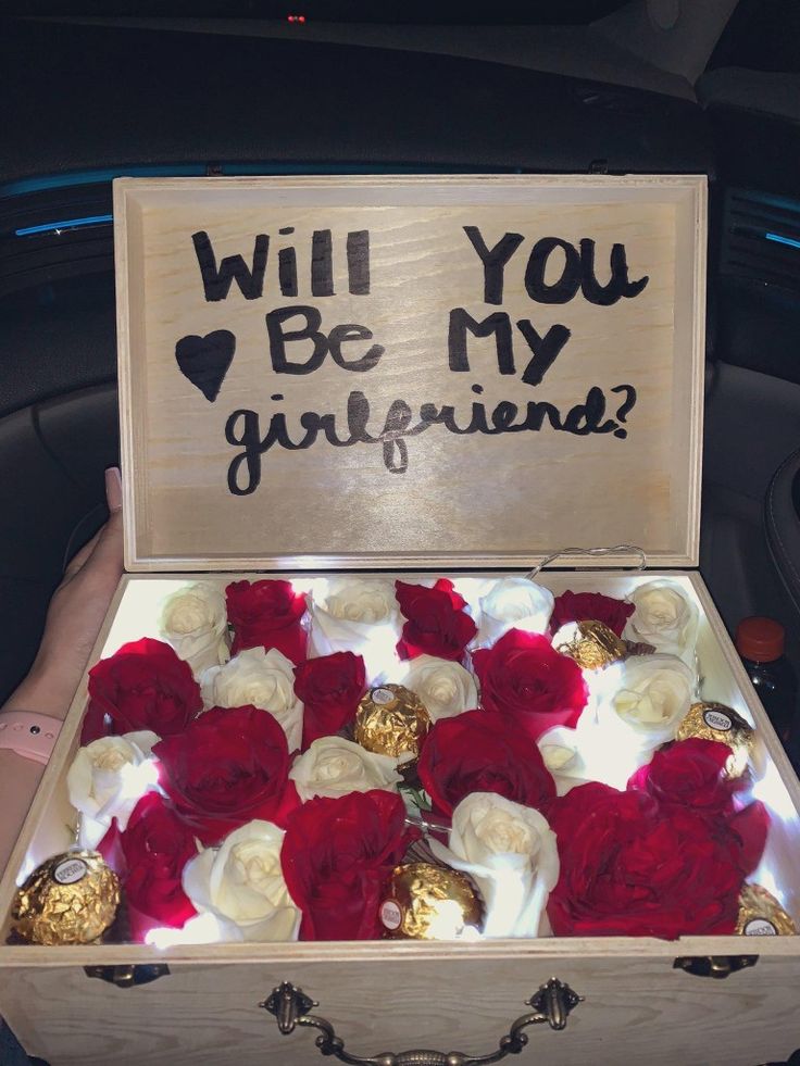 a wooden box with red and white flowers inside that says will you be my girlfriend?