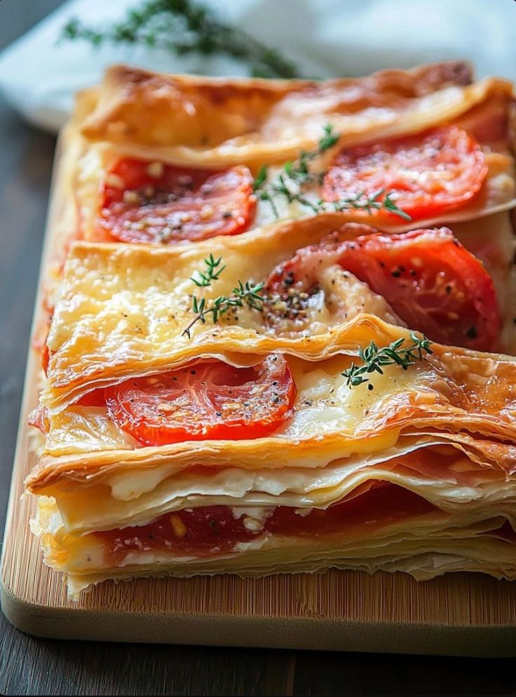 a wooden cutting board topped with slices of pizza covered in cheese and tomato toppings