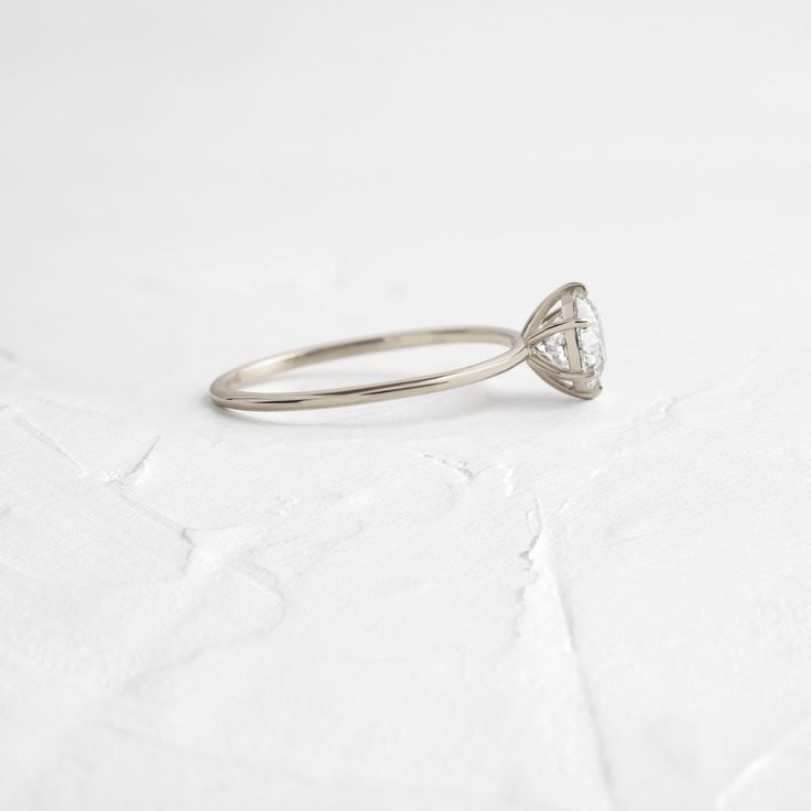 a diamond ring sitting on top of a white surface with the center stone cut in half