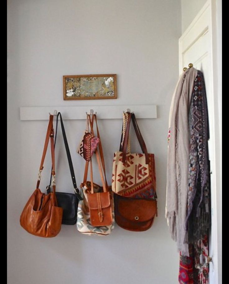 several purses hanging on the wall in a room