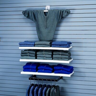 clothes are hanging on shelves in front of a garage door