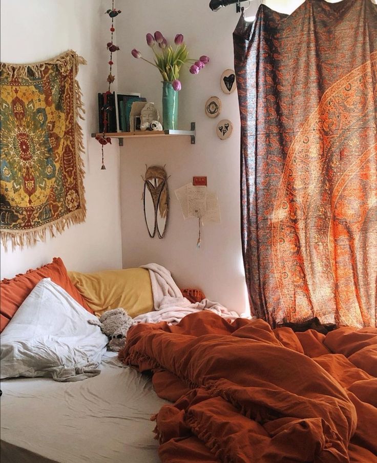 an unmade bed in a bedroom with orange sheets and blankets on top of it