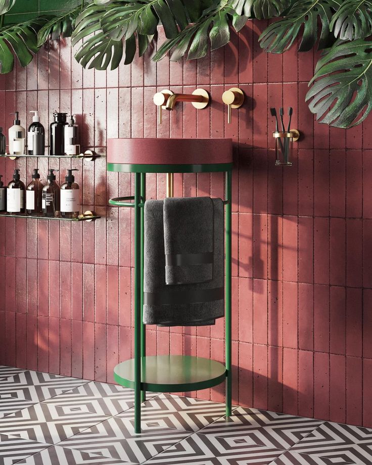 a bathroom with pink walls and floor tiles, a green pedestal sink and towel rack on the wall