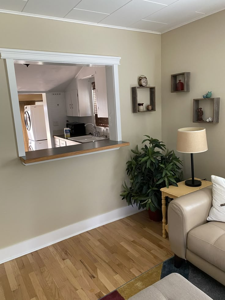 a living room filled with furniture and a large mirror on the wall above it's windows